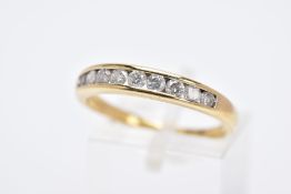 AN 18CT GOLD DIAMOND HALF HOOP RING, set with a row of channel set round brilliant cut diamonds,