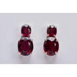 A PAIR OF 9CT WHITE GOLD GARNET DROP EARRINGS, each designed with two claw set, oval cut garnets