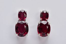 A PAIR OF 9CT WHITE GOLD GARNET DROP EARRINGS, each designed with two claw set, oval cut garnets