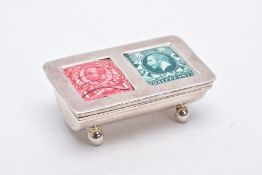 A WHITE METAL AND ENAMEL STAMP CASE, of a half barrel shape, set with a red and green enamel stamp