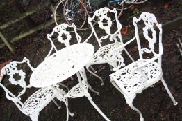 A WHITE CAST ALUMINIUM GARDEN TABLE 67cm in diameter and four similar chairs