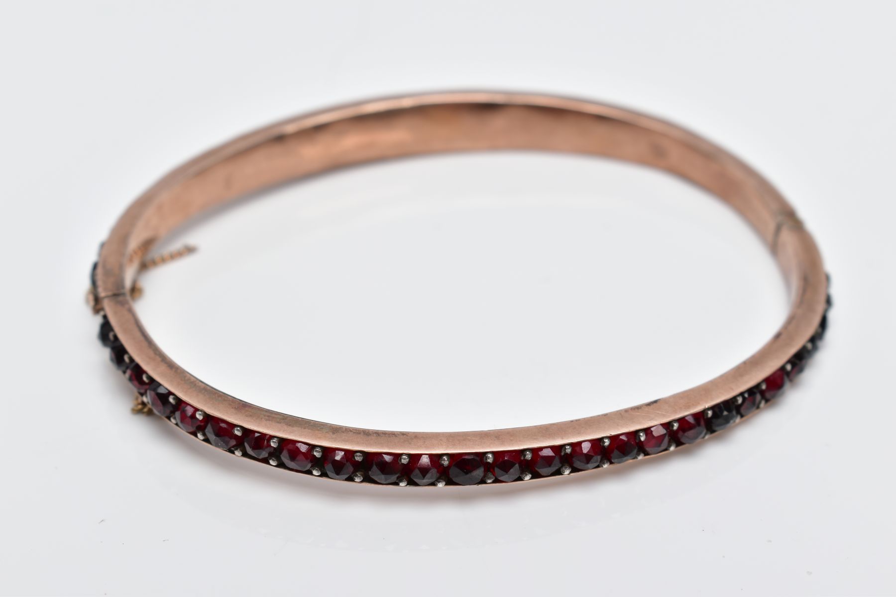 A ROSE GOLD PLATED HINGED BANGLE, set with rose cut red and orange garnets all round, fitted with - Image 4 of 4