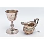 A SILVER CREAM JUG AND A WHITE METAL GOBLET, the Geo.V cream jug with a fluted panel to the body