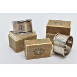TWO CASED SILVER NAPKIN RINGS each of an engine turn design engraved initial 'E' on one and 'R' on