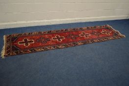 A KAZAK CARPET RUNNER, on a red field, and multi strap border, length 305cm x 76cm