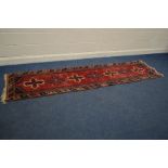 A KAZAK CARPET RUNNER, on a red field, and multi strap border, length 305cm x 76cm