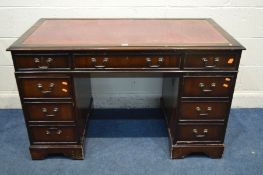 A MAHOGANY PEDESTAL DESK with a burgundy leather and gilt tooled inlay top, above nine drawers,