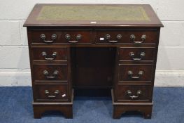 A MODERN MAHOGANY KNEE HOLE DESK with a green leather and gilt tooled inlay top, above eight drawers