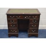 A MODERN MAHOGANY KNEE HOLE DESK with a green leather and gilt tooled inlay top, above eight drawers