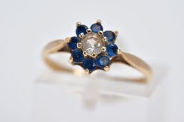 A 9CT GOLD CLUSTER RING, the raised cluster designed with a central circular cut colourless stone