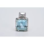 A WHITE METAL BLUE TOPAZ PENDANT, of a square shape, designed with a claw set square cut blue