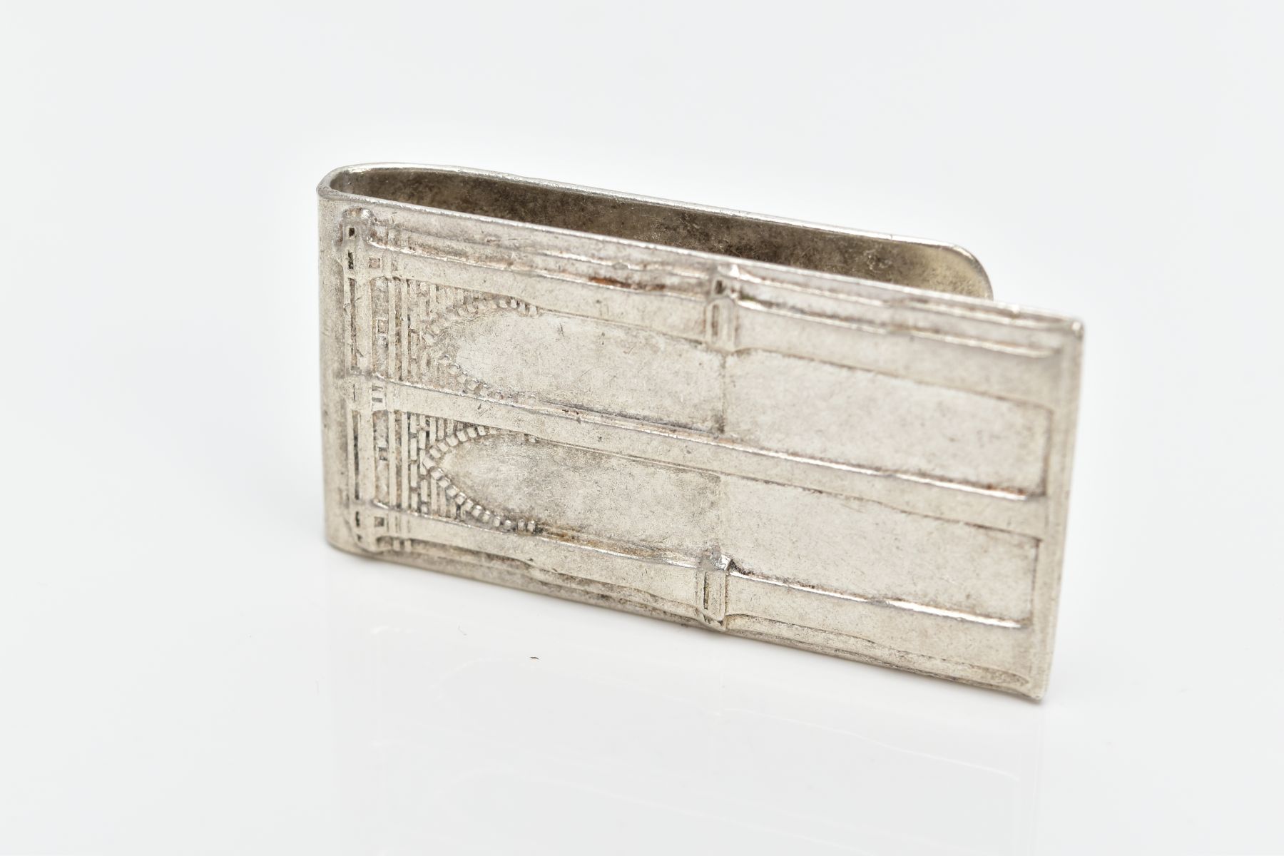 A WHITE METAL MONEY CLIP, designed with a motif of two brick and pillar arches, approximate length