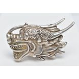A WHITE METAL ORIENTAL BELT BUCKLE, in the form of a dragon head oriental stamps to the reverse,