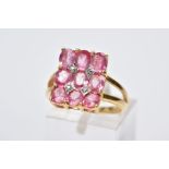 AN 18CT GOLD RING, designed with a rectangular panel set with nine claw set oval cut pink stones