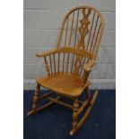 A BEECH SPINDLE HOOP BACK WINDSOR ROCKING CHAIR (sd to front left leg)