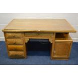 AN EARLY TO MID 20TH CENTURY ASH DESK, with five drawers, and single cupboard doors, width 156cm x