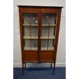 AN EDWARDIAN MAHOGANY AND STRUNG ASTRAGAL GLAZED TWO DOOR DISPLAY CABINET, on square tapering legs