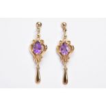 A PAIR OF AMETHYST DROP EARRINGS, each yellow metal earring designed with an openwork scroll drop