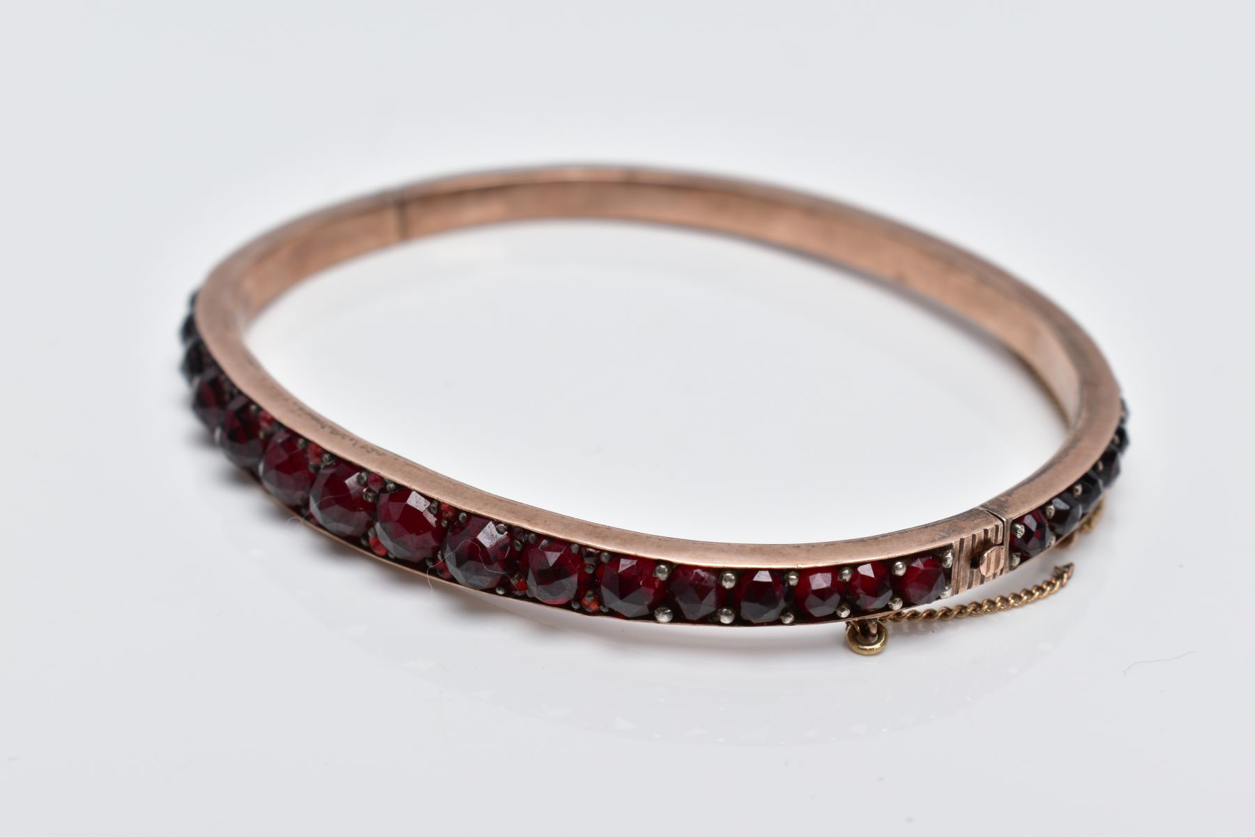 A ROSE GOLD PLATED HINGED BANGLE, set with rose cut red and orange garnets all round, fitted with - Image 2 of 4