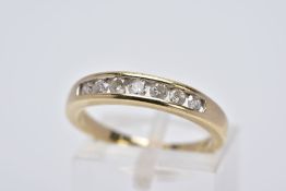A 9CT GOLD DIAMOND HALF HOOP RING, designed with a row of channel set round brilliant cut