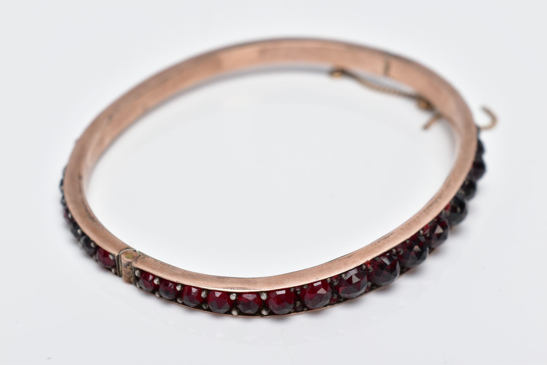 A ROSE GOLD PLATED HINGED BANGLE, set with rose cut red and orange garnets all round, fitted with - Image 3 of 4