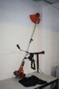 AN UNBRANDED PETROL STRIMMER with harness (engine pulls freely but hasn't been started)
