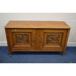 AN EARLY 20TH CENTURY GOLDEN OAK TWO DOOR SIDEBOARD with foliate carved panels fitted interior on