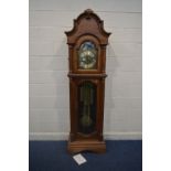 A GOLDEN OAK CHIMING LONGCASE CLOCK, arched glass door enclosing a brassed dial, with automaton