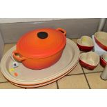 A COLLECTION OF LE CREUSET COOKWARE, comprising an orange enamelled cast iron oval casserole, twin