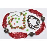 THREE GLASS BEAD NECKLACES, to include a green glass leaf and orange ball bead necklace on a white