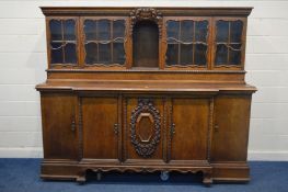A LARGE HEAVY OAK DRESSER, with elaborately carved foliate and scrolled detail, the top section with