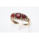 A LATE 20TH CENTURY 9CT GOLD, THREE STONE GARNET RING, designed with three graduated circular cut