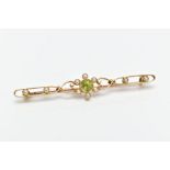 A YELLOW METAL, PERIDOT AND SPLIT PEARL BROOCH, designed with a central circular cut collet set