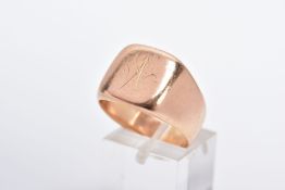 A YELLOW METAL SIGNET RING, worn engraving to the front panel, approximately 14mm x 14mm in size,