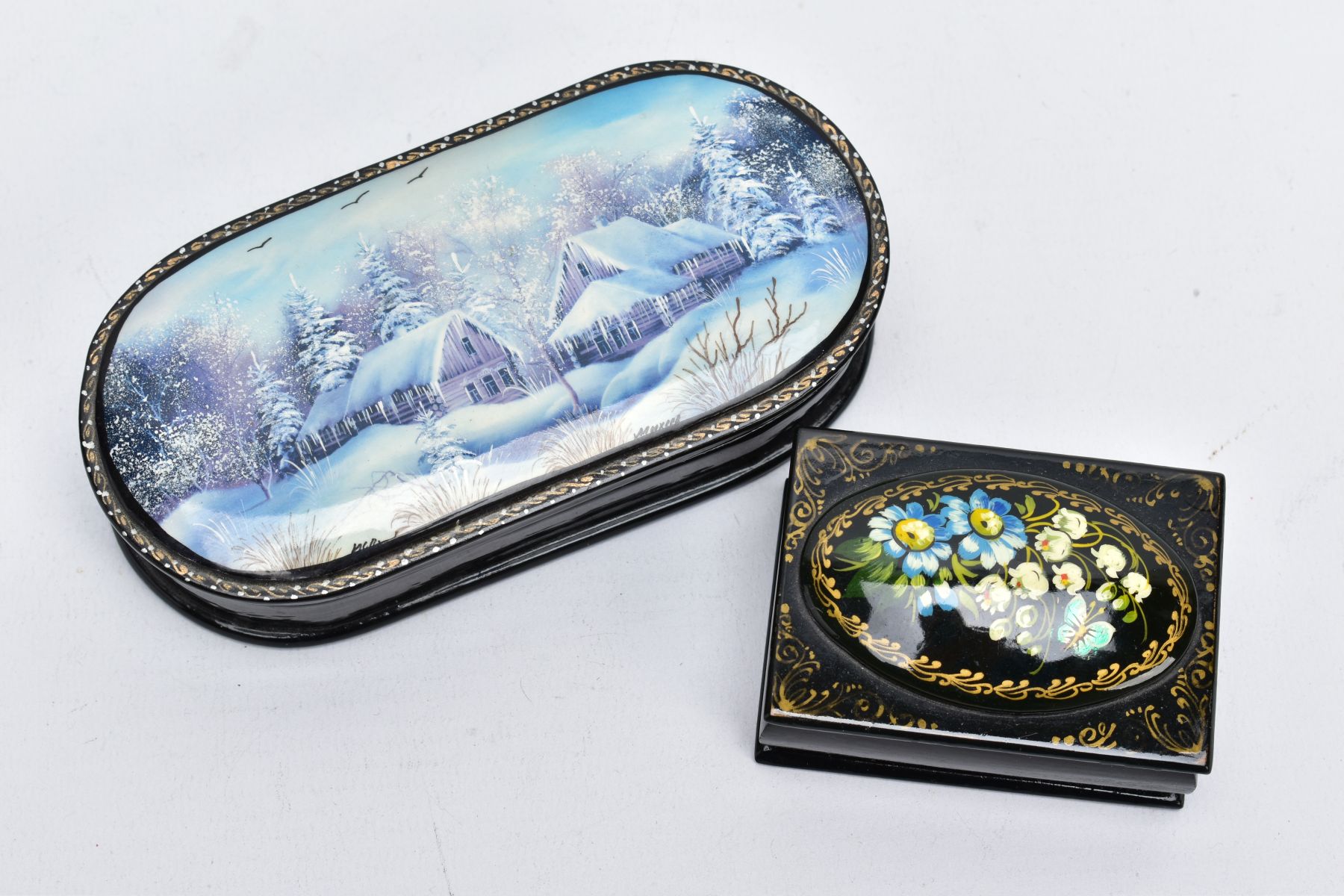 TWO DECORATIVE WOODEN TRINKET BOXES, the first of an elongated oval form, decorated with a painted