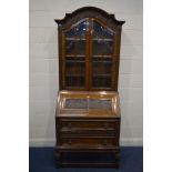 AN EARLY 20TH CENTURY OAK BUREAU BOOKCASE, with elaborate fruiting vine and grape detail, the arched