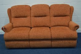 A TANGERINE UPHOLSTERED THREE SEATER SETTEE (splits into three sections)