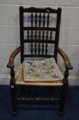 A PERIOD OAK SPINDLE BACK ARMCHAIR with a needlework seat pad