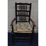 A PERIOD OAK SPINDLE BACK ARMCHAIR with a needlework seat pad