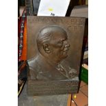 A BRONZE RELIEF PORTRAIT PLAQUE OF MILTON V. ELY C.B.E, presented by his employees on the 50th