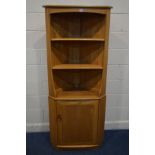 AN ERCOL MODEL 743C BLONDE ELM OPEN CORNER CUPBOARD, above a single cupboard door, width 76cm x