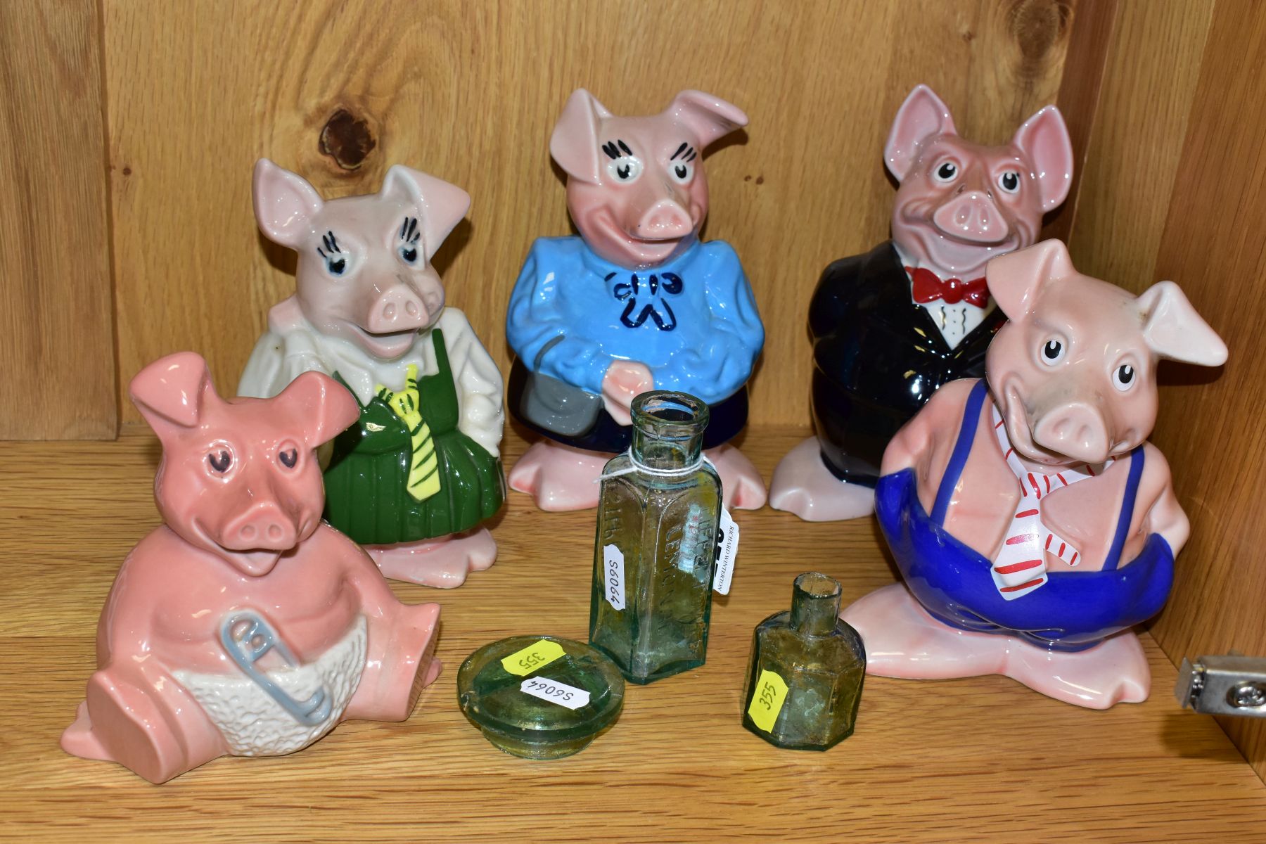 A SET OF FIVE WADE NATWEST PIGGY BANKS, all with Natwest black plastic stoppers, a clear glass