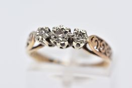 A YELLOW METAL THREE STONE DIAMOND RING, designed with three graduated illusion set single cut