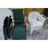 A SET OF FOUR PLASTIC STACKING GARDEN ARMCHAIRS, two folding plastic deck chairs, a folding sun