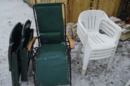 A SET OF FOUR PLASTIC STACKING GARDEN ARMCHAIRS, two folding plastic deck chairs, a folding sun