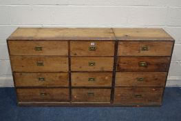 AN EARLY 20TH CENTURY PINE SIDEBOARD/BANK OF TWELVE DRAWERS, with campaign handles, width 166cm x