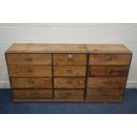 AN EARLY 20TH CENTURY PINE SIDEBOARD/BANK OF TWELVE DRAWERS, with campaign handles, width 166cm x