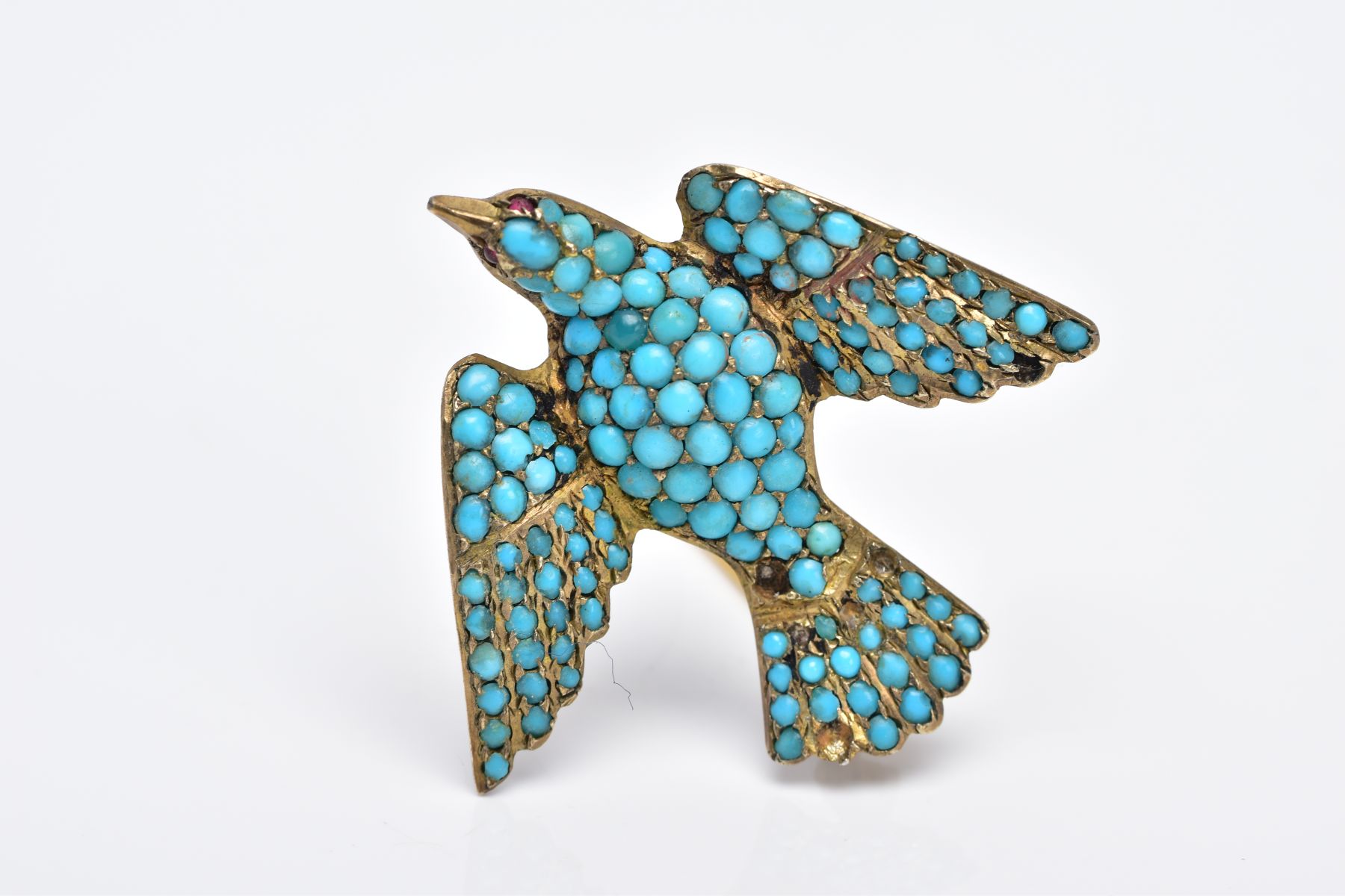 A VICTORIAN SILVER GILT TURQUOISE SET BROOCH, in the form of a bird set with red paste eyes and an