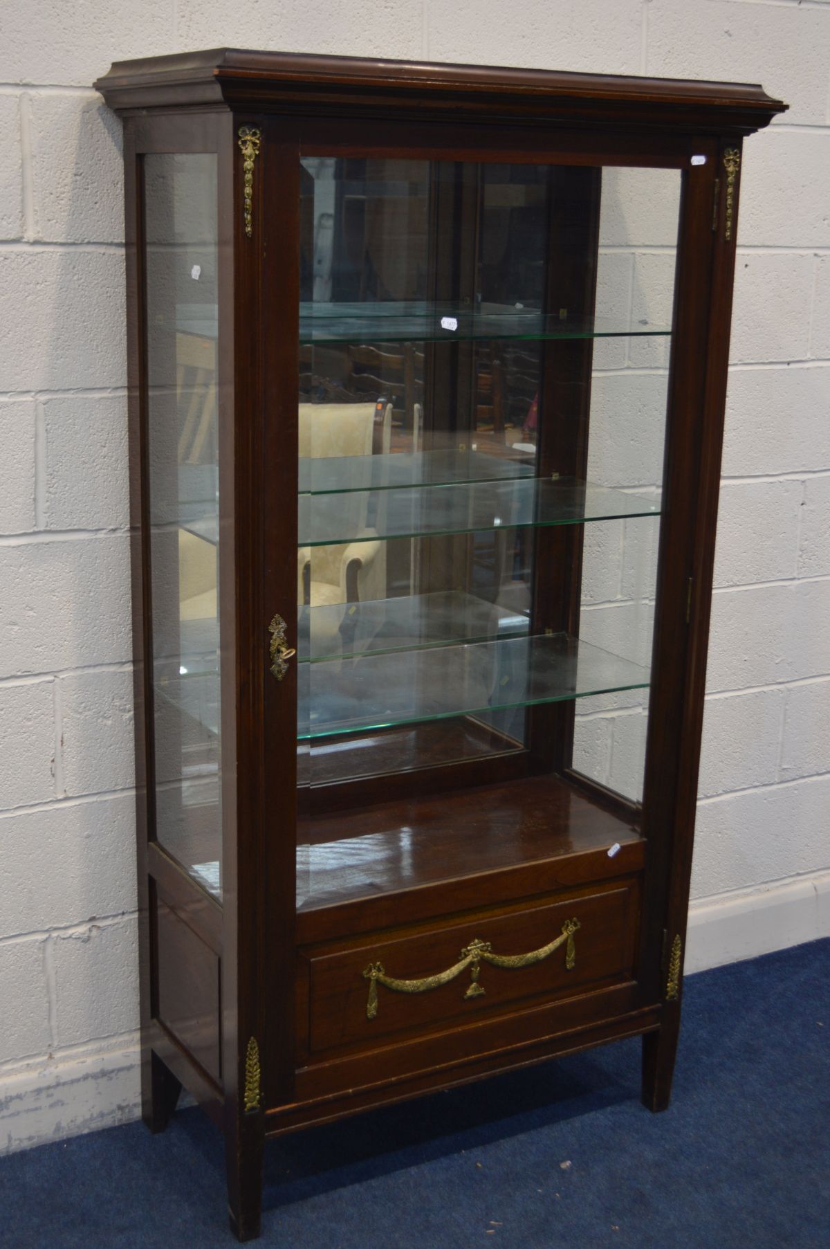 A REPRODUCTION LOUIS STYLE MAHOGANY SINGLE DOOR DISPLAY CABINET, with brass mounts, mirrored back,