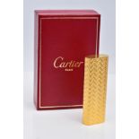 A CARTIER GOLD PLATED LIGHTER, oval rectangular form with engine turned engraving decoration, signed
